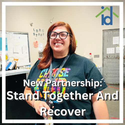 a woman with glasses smiling and text that reads "New partnership" Stand Together And Recover" with a Homeless ID Project logo in the top corner