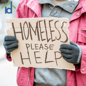 gloved hands holding a sign that reads "homeless please help"